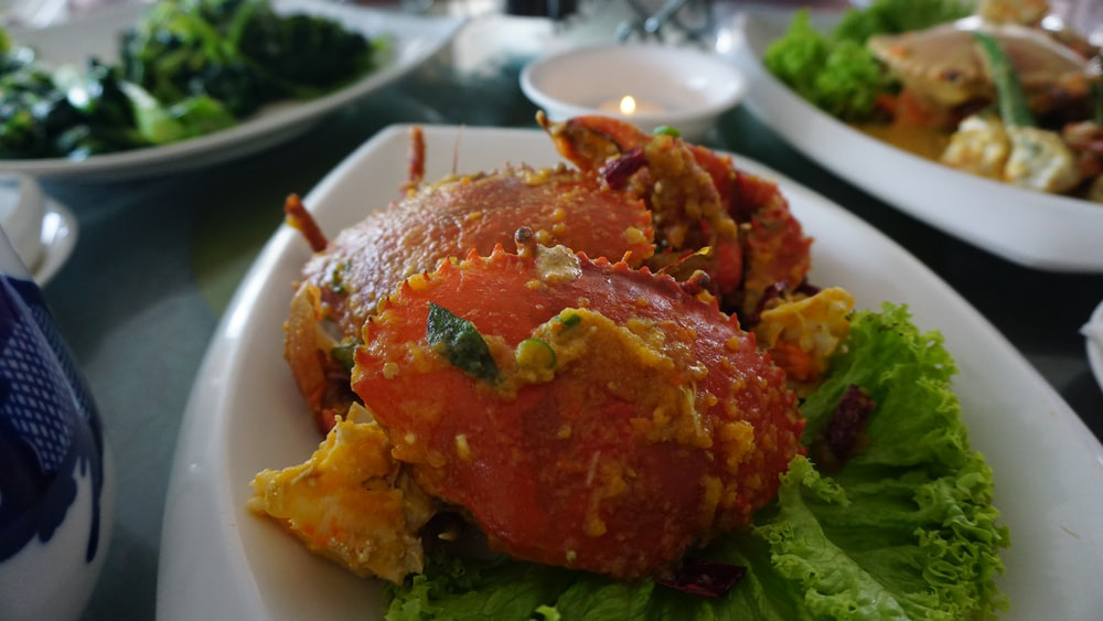 A dish of deviled crab with sauce and lettuce